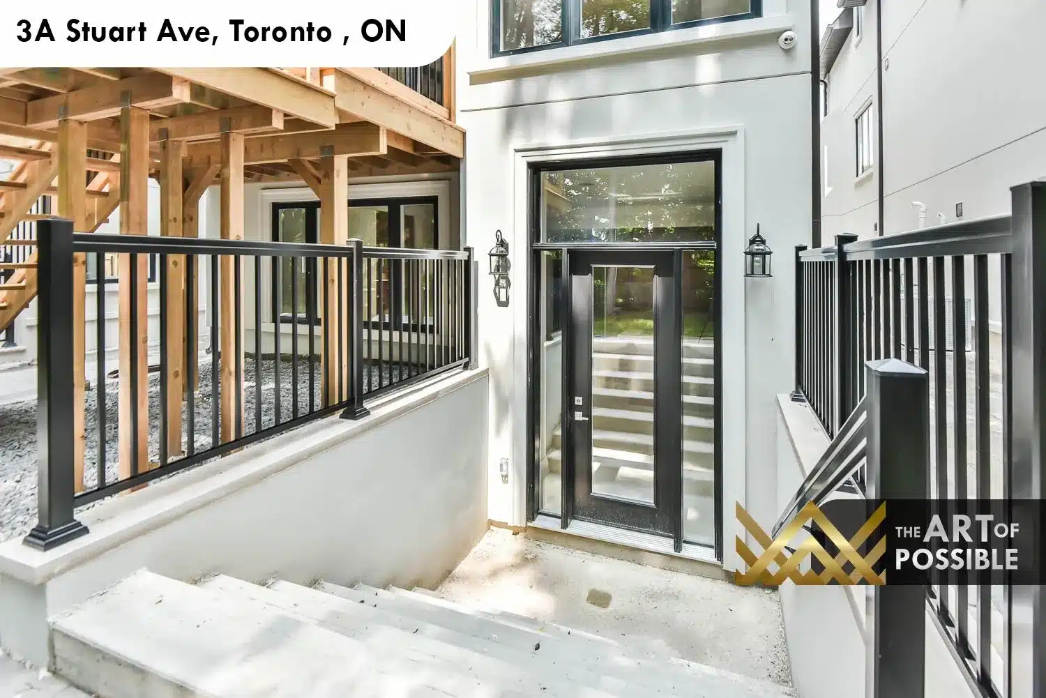 Lower level walkout entry at 3A Stuart Ave with black iron railings and cedar deck structure above
